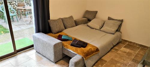 une chambre avec un lit avec un canapé et une fenêtre dans l'établissement T-2est 46m dons la maison au bord du Canal du Midi, à Saint-Hilaire-de-Lusignan