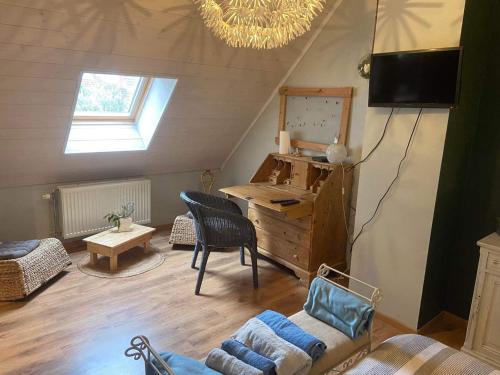 an attic room with a desk and a chair at Le petit 19 in Jodoigne