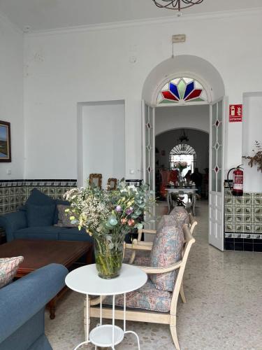 a living room with a vase of flowers on a table at HOSTAL LA CRUZ 1872 in Chipiona