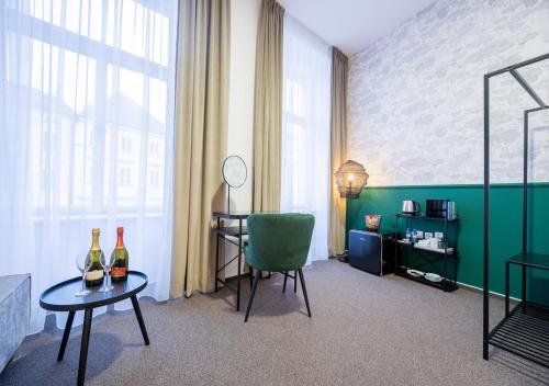 um quarto com uma cadeira e uma mesa com duas garrafas de vinho em Casa em Hradec Králové