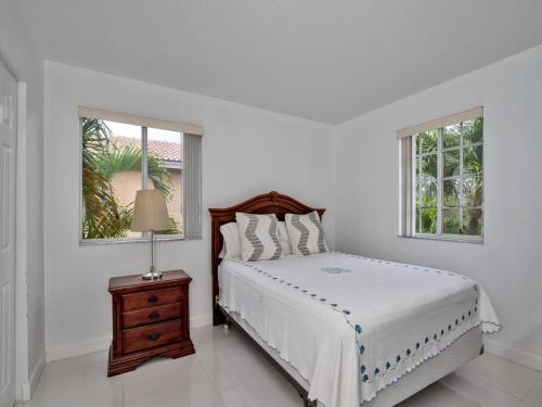 1 dormitorio blanco con 1 cama, mesita de noche y 2 ventanas en Gorgeous Rooms in Miramar Prestigious State Home - Min 31 Days Rental, en Miramar