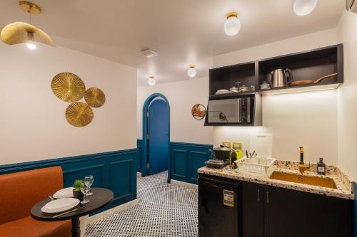 uma cozinha com armários azuis, um lavatório e uma mesa em The Neat Nostalgic 2BDR Apt Cairo's Downtown no Cairo