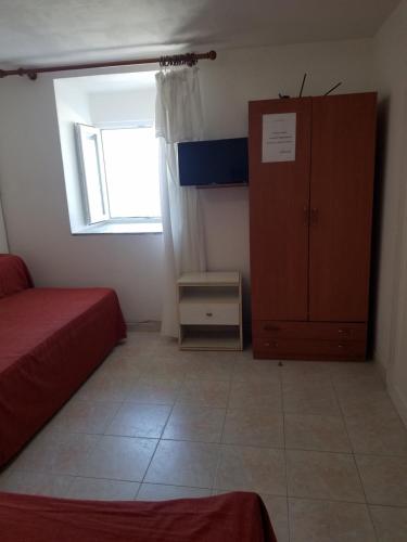 ein Schlafzimmer mit einem Bett, einem Schrank und einem Fenster in der Unterkunft Casadelpino Residence La Piana in Ponza