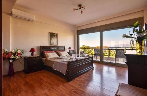 a bedroom with a bed and a large window at VillaBayViewCrete in Hersonissos