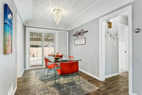a dining room with a table and red chairs at CUTE Remodeled Midcentury Cottage on Boise Bench in Boise