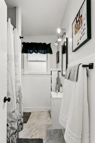 a white bathroom with a toilet and a sink at CUTE Remodeled Midcentury Cottage on Boise Bench in Boise