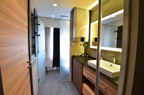 La salle de bains est pourvue d'un lavabo et d'un miroir. dans l'établissement Woodside Kopaonik Residences, à Kopaonik