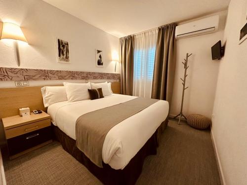 a hotel room with a large bed and a window at LUZ Vejer Hospedería in Vejer de la Frontera