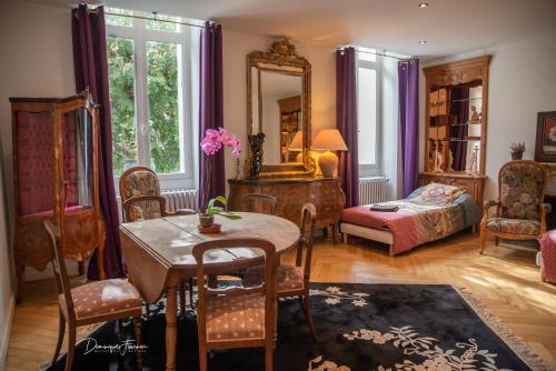 a room with a table and chairs and a bedroom at VILLA ILIXON - Appartements privés proche du centre de Luchon, parking, billard, jardin in Luchon