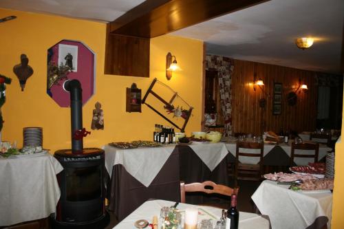 a restaurant with two tables and a wood stove at Hotel Etoile De Neige in Valtournenche