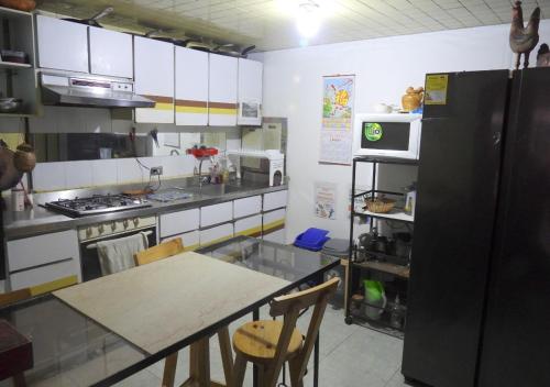cocina con mesa y nevera negra en CASA LATINO, en Bogotá