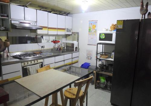 a kitchen with a table and a black refrigerator at CASA LATINO in Bogotá