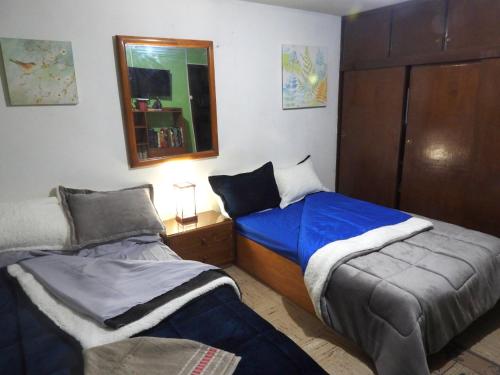 波哥大的住宿－CASA LATINO，一间卧室配有两张床和镜子