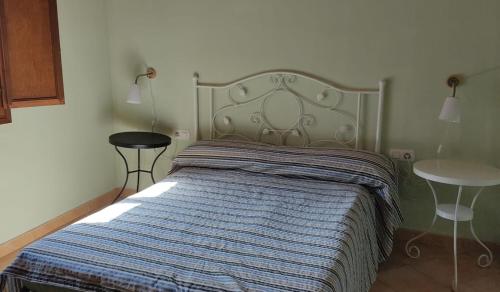 a bedroom with a bed with a blue striped blanket at CA L'AIDA RURAL in Montblanc