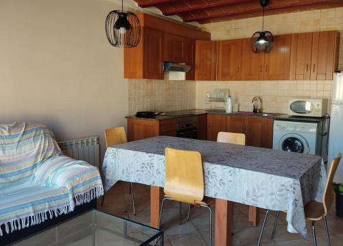 a kitchen with a table and chairs and a table and a couch at CA L'AIDA RURAL in Montblanc