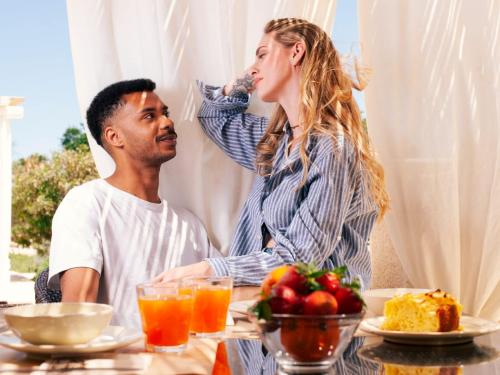 een man en een vrouw aan een tafel met eten bij Trulli IsAgo in Locorotondo