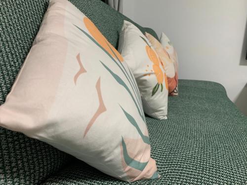 three pillows are sitting on a green couch at Daiwen Homestay in Jiaoxi