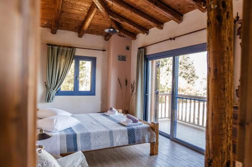 a bedroom with a bed and a large window at Chaihoutes stone villa into Olive farm in Zia in Ágios Dimítrios