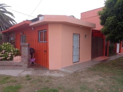 una pequeña casa con una puerta roja en La Positiva en Mar de Ajó