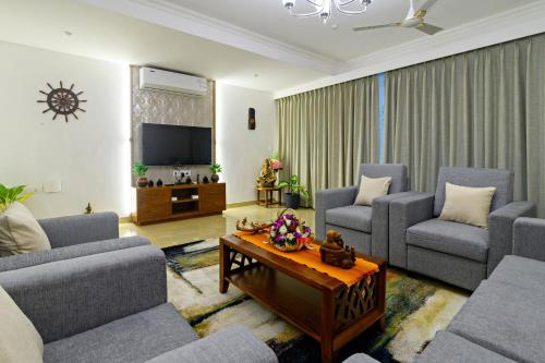 a living room with two couches and a tv at Lotus & Orchid Villas by Ramnath Homes in Sangolda