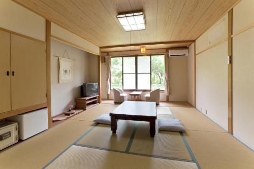 a living room with a coffee table and a couch at Tokiwaso in Miyakonozyō