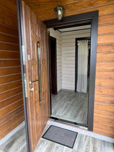 an open door of a wooden house with a porch at Villa Family House Truskavets in Modrychi