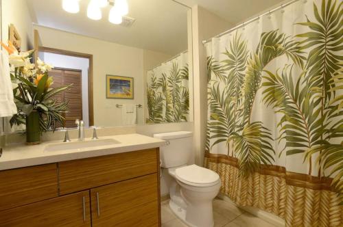 y baño con aseo y cortina de ducha. en Tropical Maui Kamaole B-Bldg, en Wailea