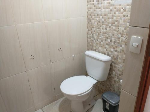 ein Badezimmer mit einem weißen WC und einer Ziegelwand in der Unterkunft O Guardião-Casa no centro de São Thomé das Letras in São Thomé das Letras