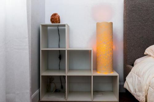 a book shelf next to a bed with a lamp at Cosy 3-Bedroom Home in Quiet Cul-de-Sac. in Pickering
