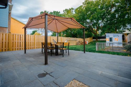 a patio with a table and an umbrella at Cosy 3-Bedroom Home in Quiet Cul-de-Sac. in Pickering