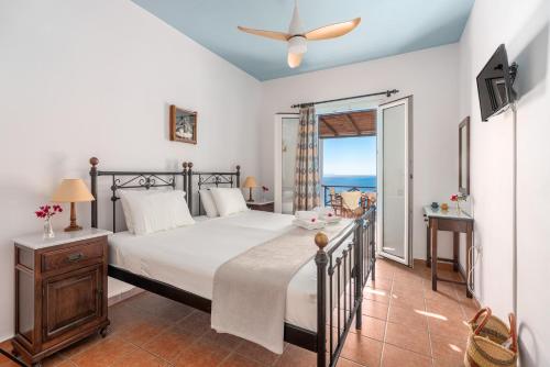 a bedroom with a bed and a view of the ocean at Reggina's Apartments in Finikas