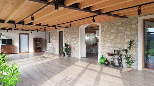 a living room with a stone wall and a wooden ceiling at Agriturismo Ponte Florio in Verona
