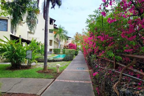 a sidewalk with pink flowers next to a building at Amazing Oceanview rooftop terrace walk to beach in Coco