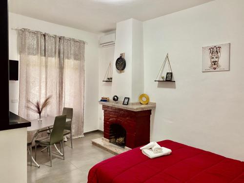 1 dormitorio con cama roja y chimenea en B&B Le Sorelle, en Giffoni Valle Piana