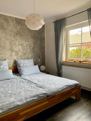 a bedroom with a large bed and a window at Ferienwohnung Kaspers in Schalkenmehren