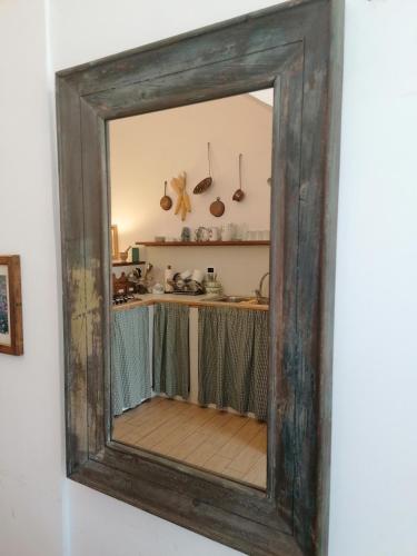 a mirror hanging on a wall next to a kitchen at Il Sorriso in Orvinio