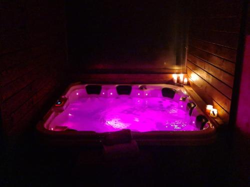 グラ・フモルルイにあるVilla Ramona SPAの- 暗い部屋の紫色のホットタブ(照明付)