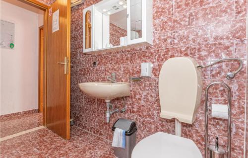 een badkamer met een wastafel, een toilet en een spiegel bij 2 Bedroom Beautiful Apartment In Ostricka Luka in Sevid