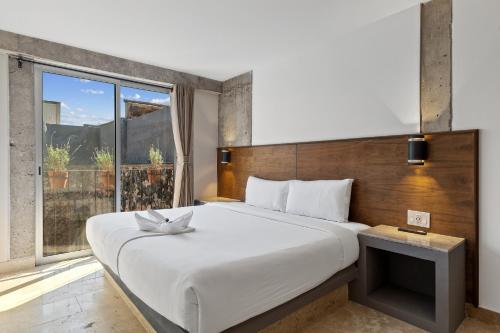 a bedroom with a large bed with a large window at Morelos By HomiRent in Querétaro