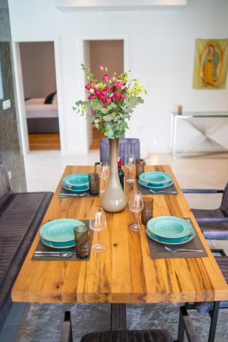 a wooden table with blue plates and a vase with flowers at Villa 7 in Međugorje