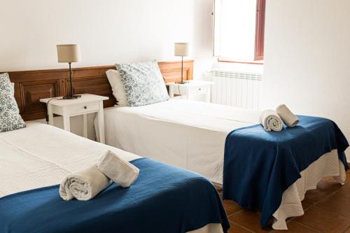 a room with two beds with towels on them at Monte Da Morena Agro-Turismo in Serpa
