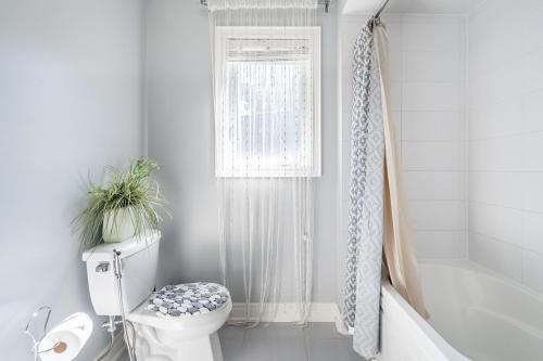 a white bathroom with a toilet and a window at Beautiful Family Villa, Pond Facing with Huge Backyard in Brampton