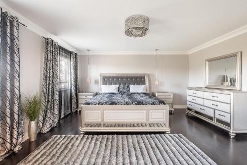 a bedroom with a bed and a dresser at Beautiful Family Villa, Pond Facing with Huge Backyard in Brampton
