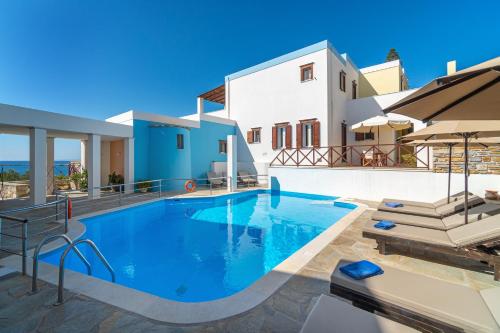 a swimming pool in a villa with a view of the ocean at Reggina's Apartments in Finikas