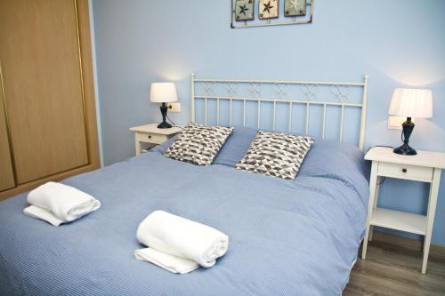 巴爾德羅夫雷斯的住宿－LAMAR Valderrobres，一张蓝色的床,上面有两条白色的毛巾