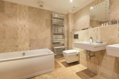 a bathroom with a sink and a toilet and a bath tub at Viridian in Carbis Bay