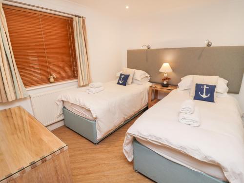 a bedroom with two twin beds and a window at Viridian in Carbis Bay