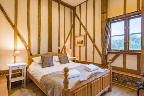 - une chambre avec un lit dans une pièce dotée d'une fenêtre dans l'établissement The Canterbury Barn by Bloom Stays, à Canterbury