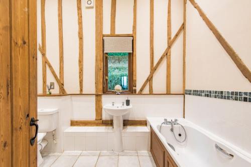 a bathroom with a tub and a sink and a bath tub at The Canterbury Barn by Bloom Stays in Canterbury