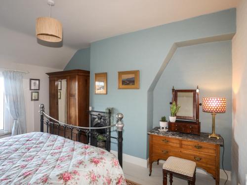 een slaapkamer met een bed en een dressoir met een spiegel bij Glasfryn in Cemaes Bay